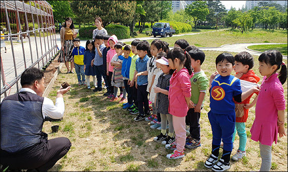 원아들이 덩굴식물 심는 방법을 배우고 있다.