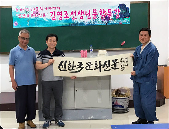 한국 유학 도중 붓글씨로 1호 박사학위를 받은 서영근 씨가 "우리문화신문"이라는 붓글씨 작품을 선물하고 있다.
