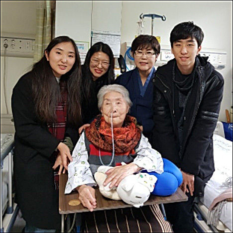 병실에서 최해련, 이지영, 박준영 서울대 언론정보학과 학생과 기자가 오희옥 지사님과 사진을 찍었다. 붉은 색 목도리를 선물로 목에 감아드렸더니 화사한 미소를 보내셨다.