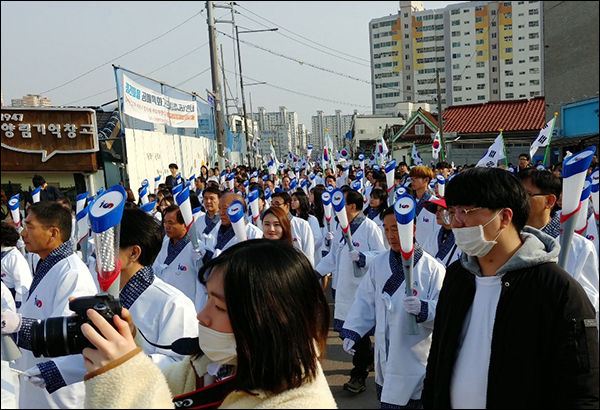 손에 태극기와 횃불봉을 든 참여자들