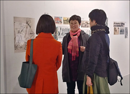 이번 전시를 기획한 도다 이쿠코(관동갤러리 관장) 씨가 일본인들에게 사진 설명을 하고 있다.(가운데 인물)