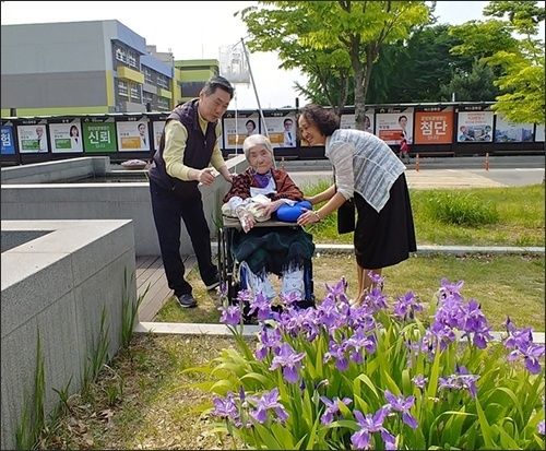 모처럼 병실을 나와서 병원 뜰에 핀 보랏빛 붓꽃을 보고 계신 오희옥 지사님과 아드님 내외