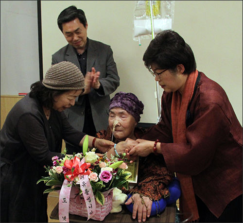 함께한 회원이 선물로 가져온 팔찌를 오희옥 지사 손목에 끼워드리고 있다.