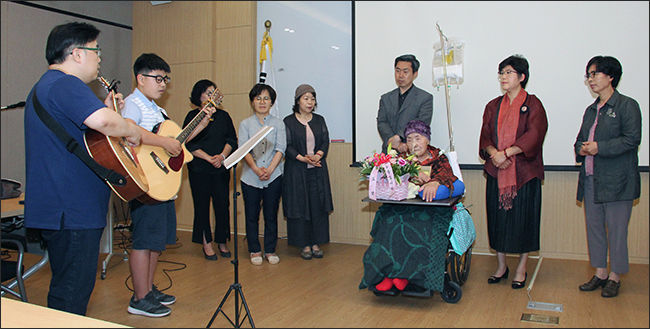 삼숭중학교 2학년 학생이 오희옥 지사를 위해 직접 윤동주 시인의 노랫말에 곡을 붙인 노래를 선사하고 있다. 왼쪽 첫번째는 이서윤 학생의 아버지 이지호 씨, 이서윤 학생, 중앙에 계신 분이 오희옥 지사 바로 뒤가 아드님 김흥태 선생