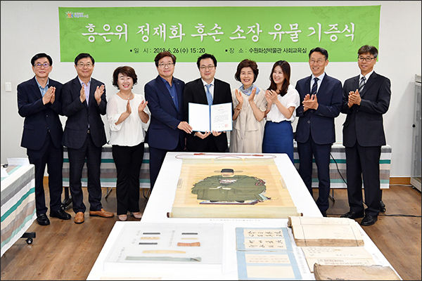 염태영 시장과 흥은위 정재화 선생 후손들이 기증식 후 정재화 선생 초상화 앞에서 기념촬영을 하고 있다