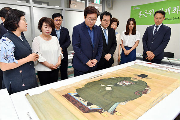 염태영 시장이 흥은위 정재화 선생 후손이 기증한 초상화를 보고 있다.