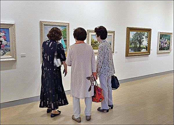 그림 감상에 빠져 있는 관람객