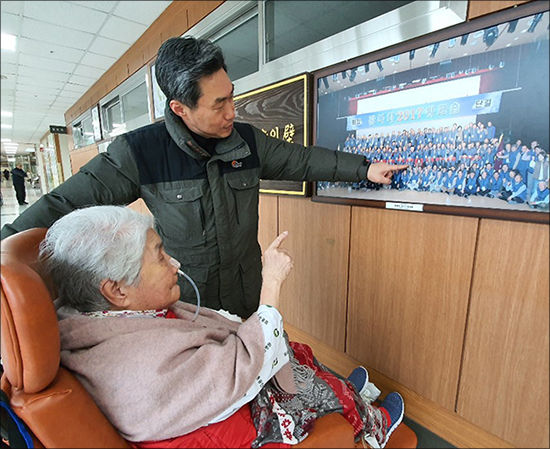 오희옥 지사가 나온 사진 앞에서 오희옥 지사와 아드님(김흥태 선생)이 함께 사진을 보고 있다.