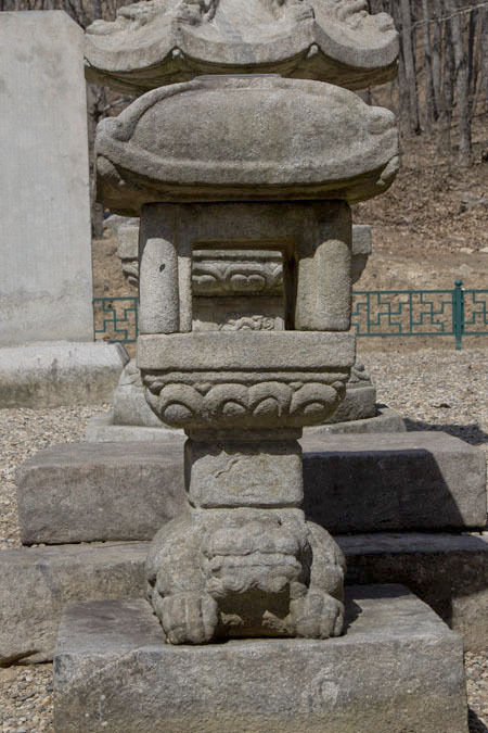 승탑 앞에 있는 석등의 정면, 가운데 불을 밝히는 화사석이 뚫려있고, 그 뒤로 승탑이 보인다.