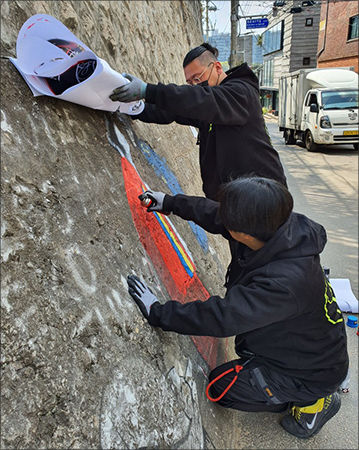 정독도서관 외벽에 독립운동가의 이미지를 그리고 있는 최성욱 작가(앞쪽)