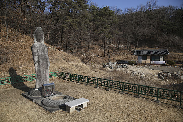 석불입상과 석불의 앞에는 석등의 좌대로 보이는 석조물이 있다.