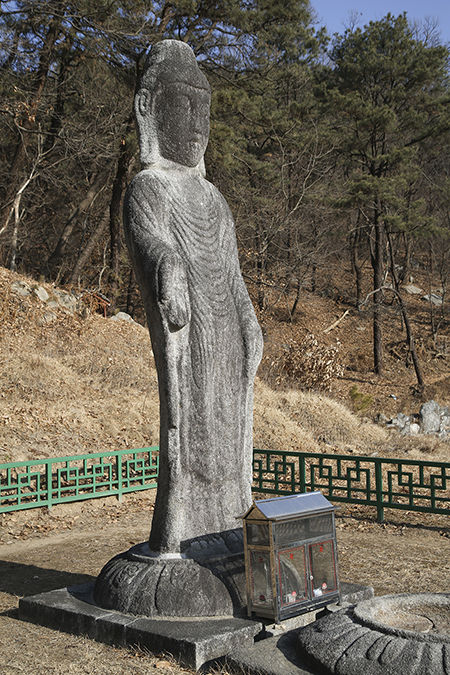 석불입상 전신, 시무외인과 여원인을 한 석불로 불상의 옷주름은 통견(어깨를 모두 감싸고 있으며 앞에서 보면 아래로 타원형의 옷주름이 있는 모습)으로 신라후기 또는 고려초기 불상의 양식을 보여주고 있다.입상의 모습은 허리가 앞으로 휘어져 있어 율동이 느껴지는 형상으로 고대 석불중에서, 매우 희귀한 모습이다.