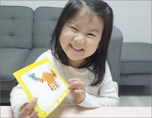 배하연(5살, 전라도 광주) 어린이가 그림엽서를 완성하고 즐거워 하고 있다.