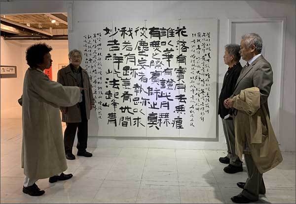 관람객들에게 작품을 설명하는 한얼 이종선 작가(왼쪽 두루마기 차림)