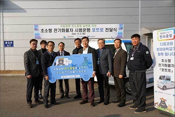 송형근 국립공원공단 이사장과 윤태화 ㈜디피코 수석부사장이 초소형 전기화물차 포트로 전달식을 하고 있다.