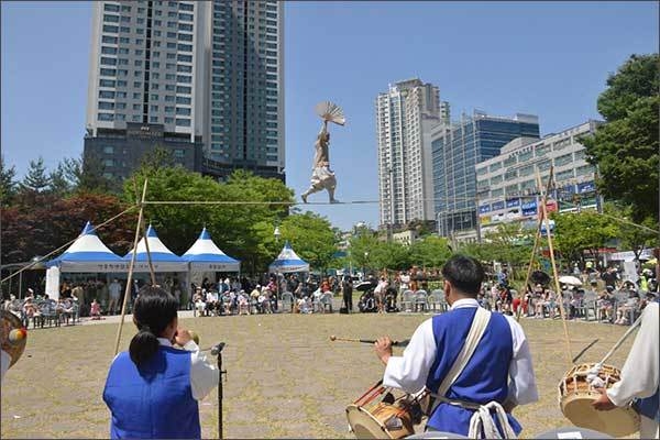 난해 6월 영통 느티나무가 있는 단오어린이공원에서 청명단오제가 재개돼 주민들이 줄타기 공연을 보고 있다.