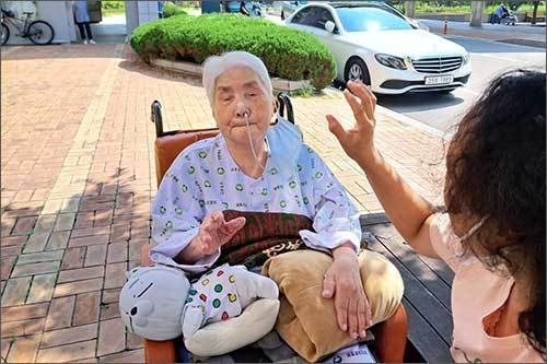 서예전을 관람하고 병원 뜰에서 며느님과 가위바위보를 하며 즐거운 한때를 보내고 계시는 오희옥 지사