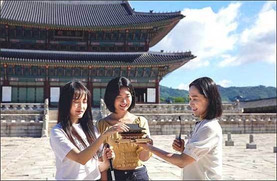 현장영상해설 탐방 참가자가 경복궁 근정전 모형을 만지며 건축 특징 해설을 듣는 모습