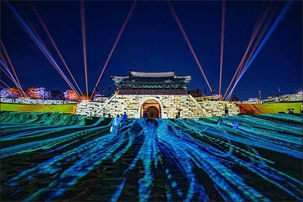 수원화성 창룡문과 성곽 및 잔디밭을 배경으로 ‘2023 수원화성 미디어아트’ 중심 작품이 상영되고 있다.