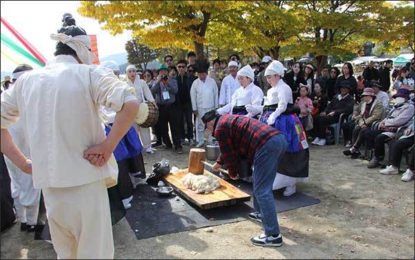 한 관람객이 떡메를 치고 있다.