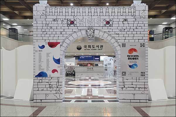 국회도서관 1층 로비에 들어선 아치형 광복 기념물, 안쪽에는 태극기 등 전시물이 있다. 