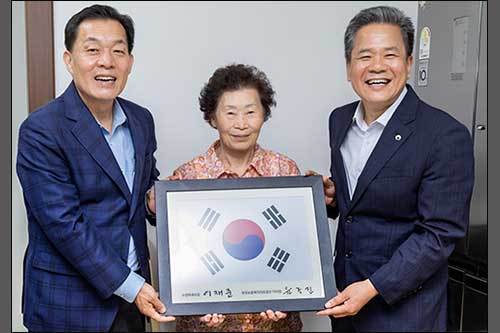 이재준 시장이 집들이에 참석해 강점순씨에게 태극기를 전달하고 있다.