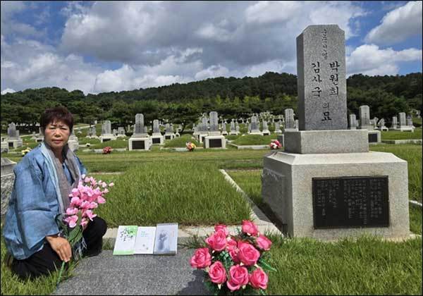 대전현충원 박원희ㆍ김사국 부부독립운동가 무덤 앞의 필자. 무덤 앞에 부부의 외동따님인 김사건 여사(1925~2010, 향년 85세)의 저서와 박원희 지사의 글이 실린 필자의 책을 나란히 바쳤다.