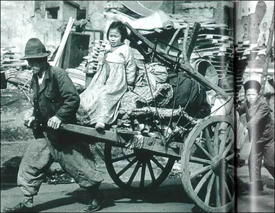 피난길 1950년 (최소한의 살림살이와 아이를 수레에 싣고 피난을 떠나는 가족입니다. 수레를 끄는 가장의 얼굴에 근심이 가득합니다. 사실 표현에 치중한 이런 사진은 전쟁을 겪지 않은 사람들에게도 당시의 비극을 생생히 전달해 줍니다.)