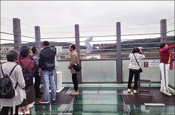 한무리의 중국인 관광객들이 망원경 앞에서 많은 이야기를 나누고 있다. 그 너머는 북한땅이다.