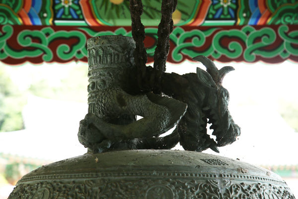 동종의 위에 있는 동종걸이로 원통형 만파식적과 용이 감싸고 있는 모습